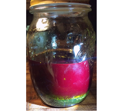 Alchemistische Zubereitung, inspiriert vom Ungarischen Wasser, mit rotem Herz und smaragdgrüner Flüssigkeit.