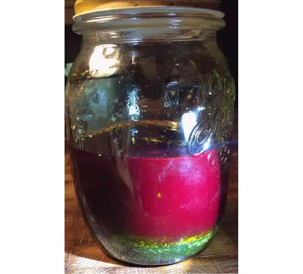 Préparation alchimique inspirée de l’Eau de Hongrie avec cœur rouge et liquide vert émeraude