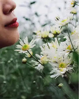 Femme respirant des fleurs blanches, illustration de l’olfaction et de la mémoire